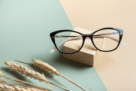 Stylish eyeglasses with ears of wheat on colored background. Optical store, vision test, stylish glasses conceptの写真素材
