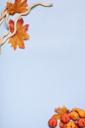 Blue background with autumn leaves and wooden branches. Copy space.の写真素材
