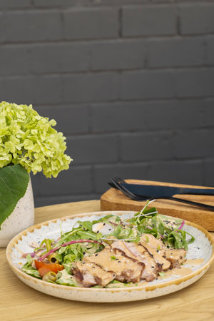 A plate with meat salad from veal on a roond wooden table.の写真素材