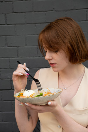 Young woman enjoying the taste of quinoa and salmon salad.の写真素材