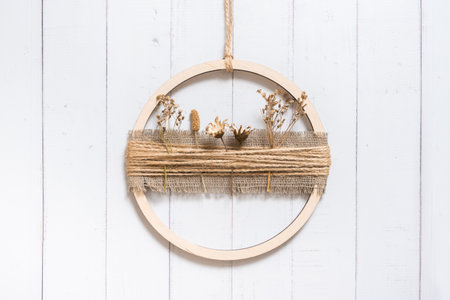 Handmade home rustic decor from a wooden circle and dried flowers on wooden background