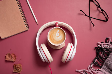 Creative flat lay composition with coffee cup and headphones on dark pink color background. Creative music, relax, online concept.の写真素材
