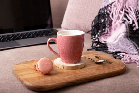 Autumn mood background with cup of cocoa, plaid and laptop on sofa. Hot drink in autumn concept.の写真素材