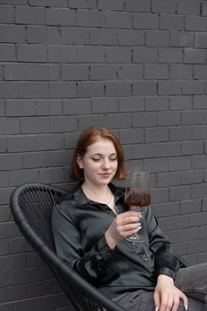 Beautiful young girl with coffee in a glass on the terrace.の写真素材