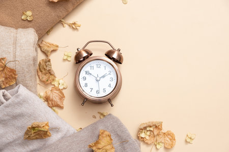 larm clock and cozy sweaters with copy space on beige background. Top view.の写真素材