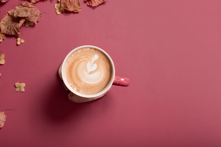 Autumn flat lay composition with dry leaves and coffee latte cup on dark pink color background. Creative autumn, thanksgiving, fall, halloween concept. Top view, copy space.の写真素材