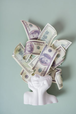 Fiinancial goals creative concept. Plaster head with cash money hundred dollars.の写真素材