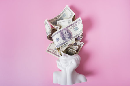 Fiinancial goals creative concept. Plaster head with hundred dollars on pink background top view