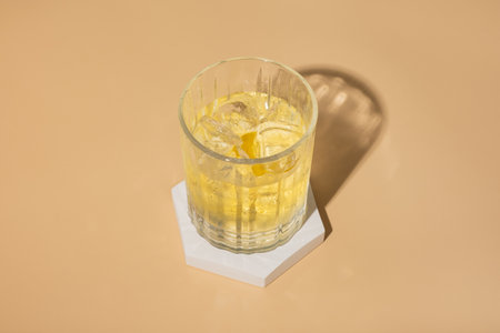Alcoholic cocktail on a podium on a colored background. Minimalist drinks conceptの写真素材