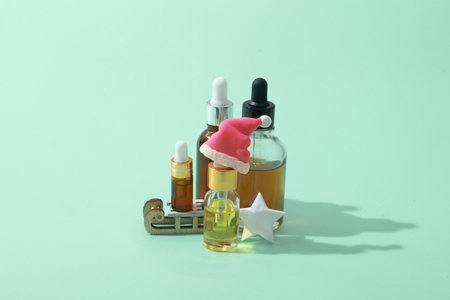 Cosmetic oil and serum bottles with pipette and christmas decor santa hat, starの写真素材