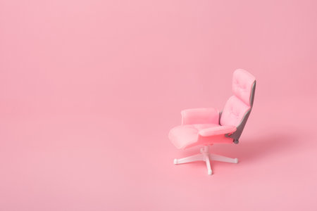 Doll office chair on a pink background. Monochrome business concept.の写真素材