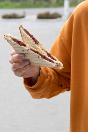 Sausage sandwich in the females hand. Street food concept.の写真素材