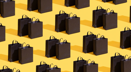 Pttetn made from black paper shopping bags on yellow background. Black friday sale, shopping concept. Bannerの写真素材