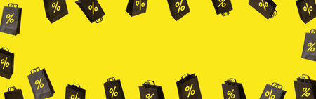 Banner with black sale shopping bags are flying on yellow background. Black Friday creative idea conceptの写真素材