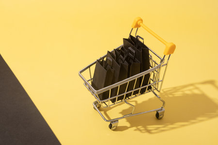 Miniature supermarket cart with shopping bags in black friday saleの写真素材