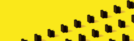 Creative pattern with black shopping bags sale on yellow background banner format with copy space