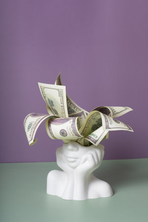Plaster head with cash money on coloured background. Thoughts about money, earnings creative concept.の写真素材
