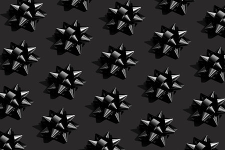 Shiny black bow on a black background. Black friday monochrome concept