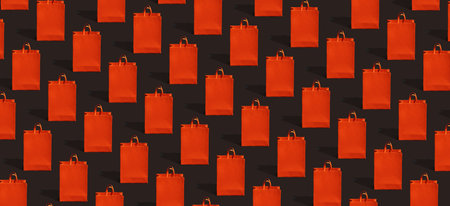 Black friday sale, shopping concept. Red paper shopping bag pattern on black background.