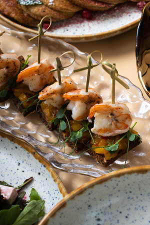 Close up shrimp and mango chutney canapes in glass plate. Mini sandwiches and other dishes.の写真素材