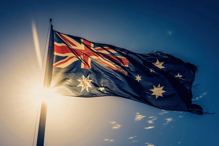 Australia flag on sunny sky background. Symbol happy australia dayの素材