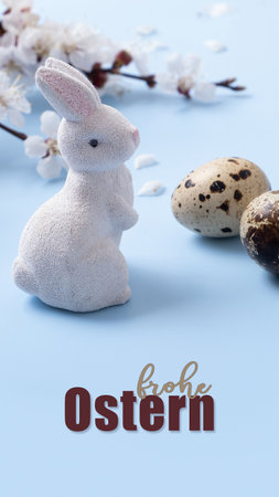 Frohe Ostern text Happe Easter in German. Rabbit with eggs and flower branch on a blue banner background.の写真素材