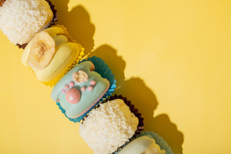 Set of different macaroons on yellow background top view, flat lay.の写真素材