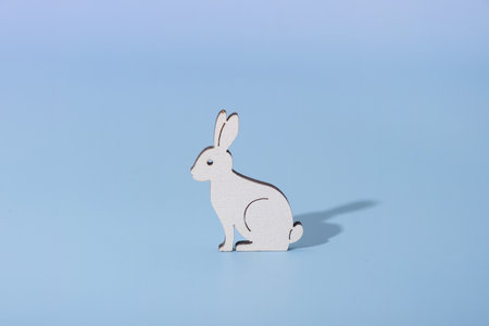 Wooden rabbit symbol for Easter on a blue background.の写真素材