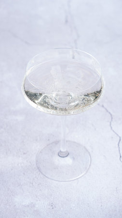 Glass of white wine on a white table. Close-up.の写真素材