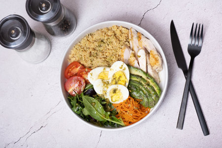 Bowl of couscous, meat, eggs and avocado, vegetables top view. Healthy balanced food conceptの写真素材