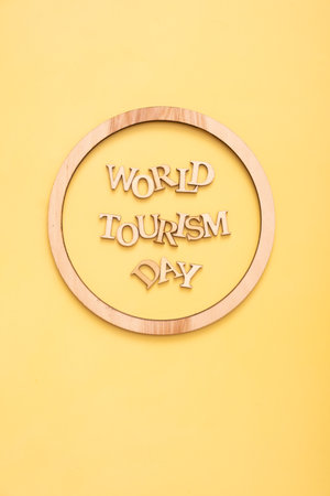 World Tourism Day text from wooden letters on a yellow background with round frame. High quality photoの写真素材