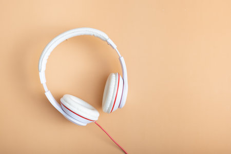 White-colored headphones on pastel beige background. Minimalistic fashion music concept. Trendy pastel color concept. Copy space. Top view, flat lay.の写真素材