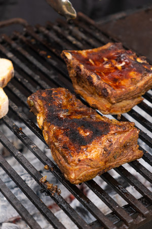 Marinated pork ribs are cooked on the coals of barbecueの写真素材