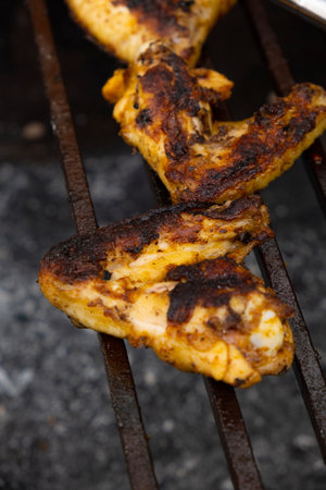Chicken wings are nicely fried on the coals of the barbecueの写真素材
