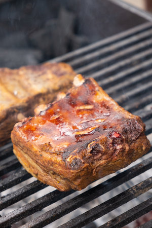 Close up marinated pork ribs are cooked on the coals of a barbecueの写真素材