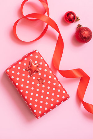 Christmas present flat lay on pink background. Top view xmas gift box with decorationsの写真素材