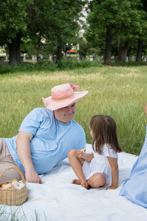 Dad and daughter having fun on a picnic. Family vacation in nature.の写真素材