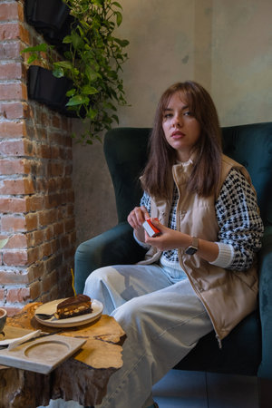 Beautiful brunette with cake and candle in cafe.の写真素材