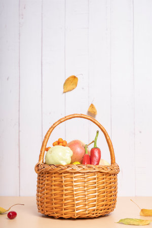 Autumn harvest basket with apples, zucchini and peppers on a wooden background. Vertical photoの写真素材