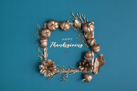 Happy Thanksgiving lettering with flat lay golden pumpkins and acorns on a turquoise background. creative greetingの写真素材