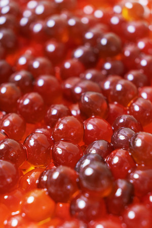A close-up view captures an array of glossy tapioca pearls soaking in sweet, vibrant syrup. Their rich colors make them an eye-catching addition to bubble tea.の写真素材