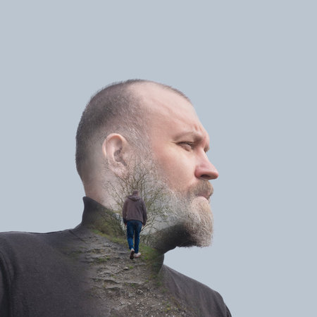 A man with a beard looks thoughtfully to the side, his profile merging with the road, symbolizing...