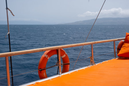 Brightly colored boat deck by the blue sea water.の写真素材