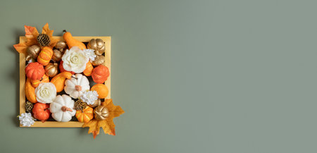 Golden frame with pumpkins, roses and maple leaves. Autumn banner with copy space.