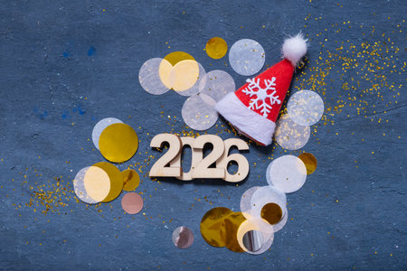 Colorful celebration of the year 2026 with festive decorations including a red hat and glitter