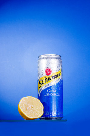 Berdyansk, UKRAINE -August 05, 2021: Schweppes Clear lemonade drink in a tin can blue background....
