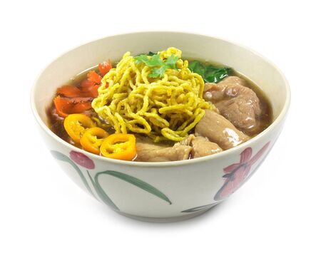 Crispy Egg Noodles with pork ,kale  Chinese vegetables in gravy soy sauce soup Chinese style decorate with carved carrots popular food in street food of Thailand side view の写真素材