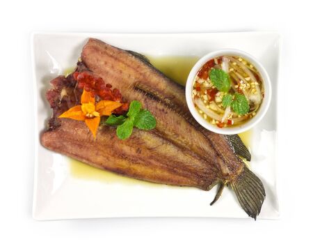 Fried Fish in fish sauce Thai food style and seafood dipping sauce decorate with carved chili top...
