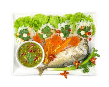 Fried mackerel (Maing-PLA-too) and fresh vegetables serving with Thai rice small noodles and seafood sauce deepping Thai appetizer salad Thai style side view top view の写真素材