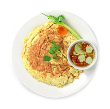 Omelet fried eggs Thai food style inside dish decorate with carved vegetables, carrots, spring onion with fish sauce spicy dipping side viewの写真素材